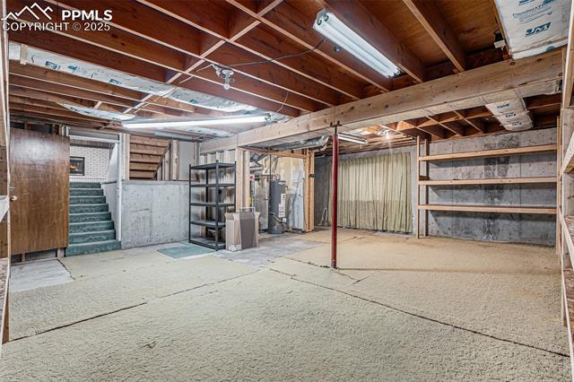 1653 Cragin Road Colorado Springs, CO 80920 - Photo 20 of 27 Unfinished basement featuring stairs and gas water heater