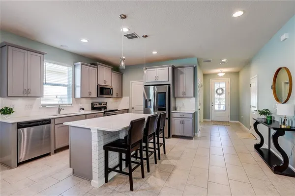 a kitchen with white cabinets stainless steel appliances and a sink