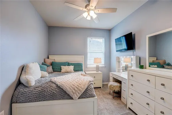 a bedroom with a bed and a ceiling fan