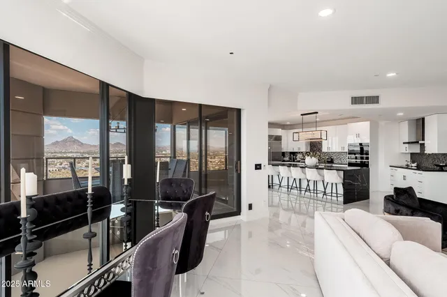 a large kitchen with granite countertop a counter space chairs stainless steel appliances and cabinets