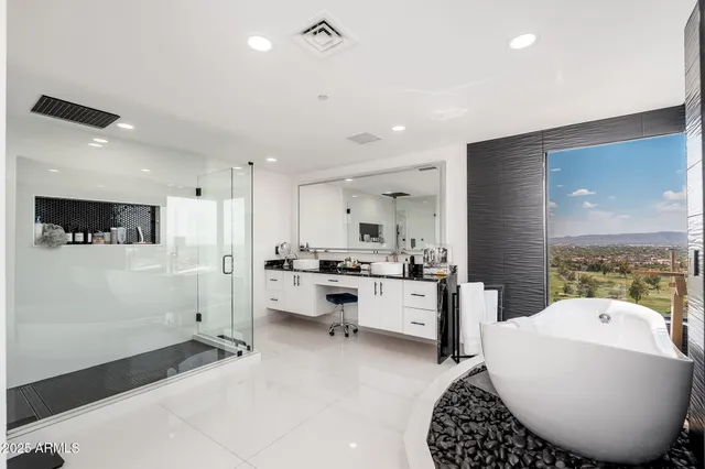 a spacious bedroom with a large bed chandelier and a window