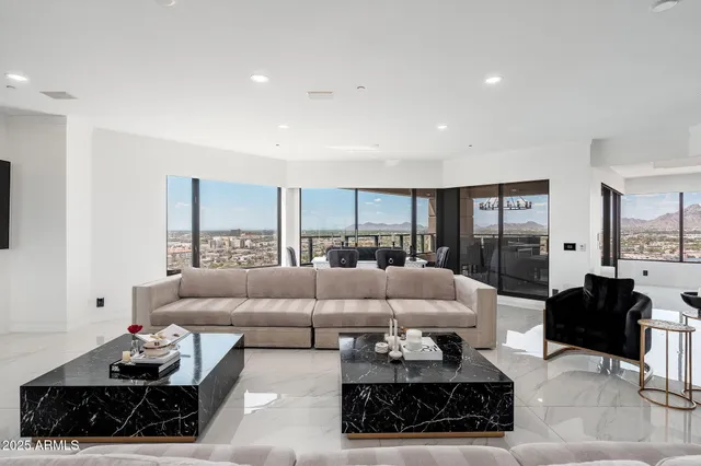 a living room with furniture a table and a large window