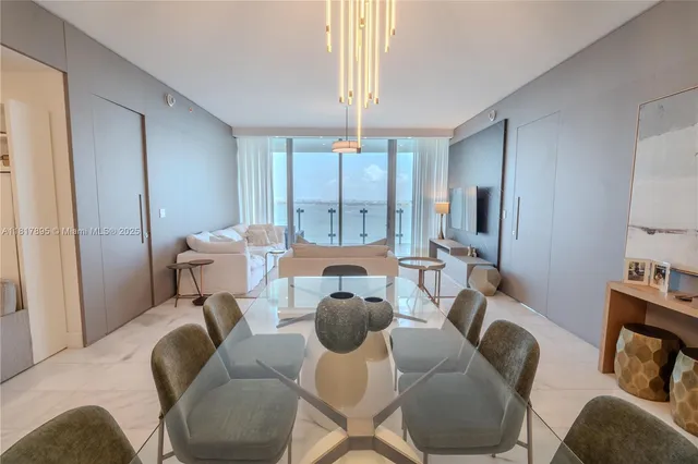 a living room with furniture a chandelier and a large mirror