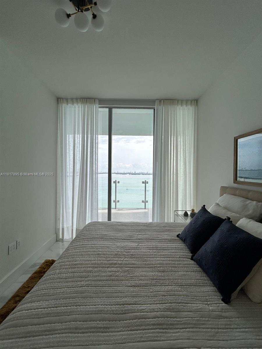 700 Northeast 26th Terrace, Unit 2602 Miami, FL 33137 - Photo 18 of 38 a bedroom with a bed and a large window