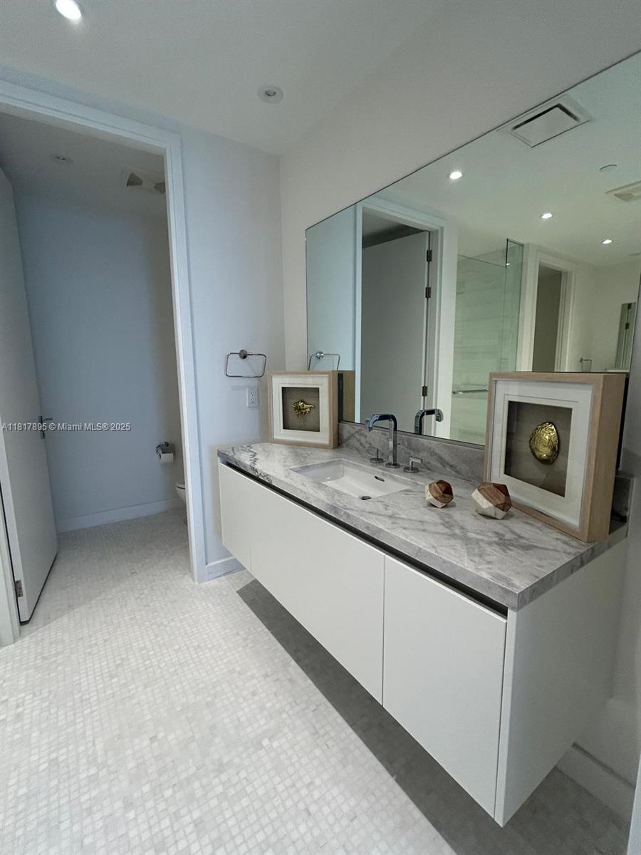 700 Northeast 26th Terrace, Unit 2602 Miami, FL 33137 - Photo 23 of 38 a bathroom with a double vanity sink and a mirror