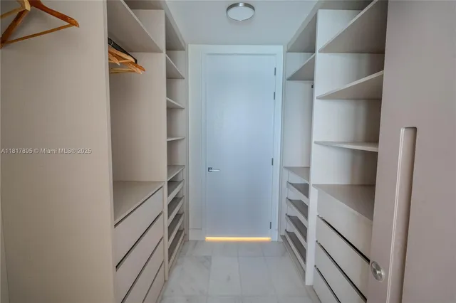 a view of walk in closet with empty racks