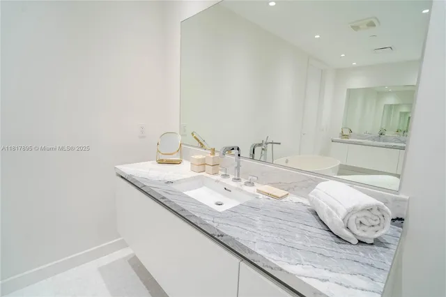 a bathroom with a granite countertop sink and a mirror