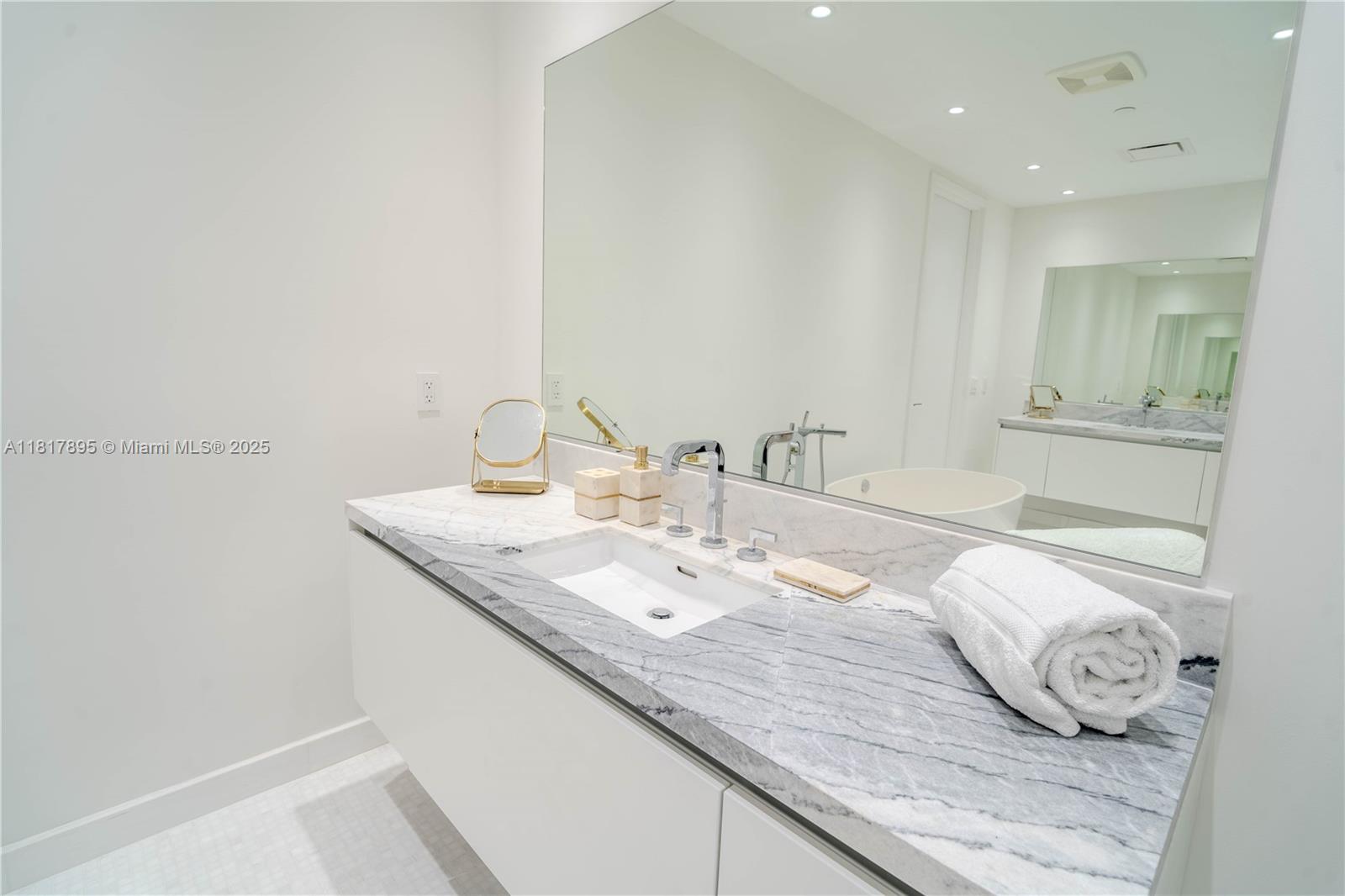 700 Northeast 26th Terrace, Unit 2602 Miami, FL 33137 - Photo 33 of 38 a bathroom with a granite countertop sink and a mirror
