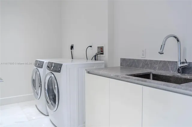 a utility room with sink washer and dryer