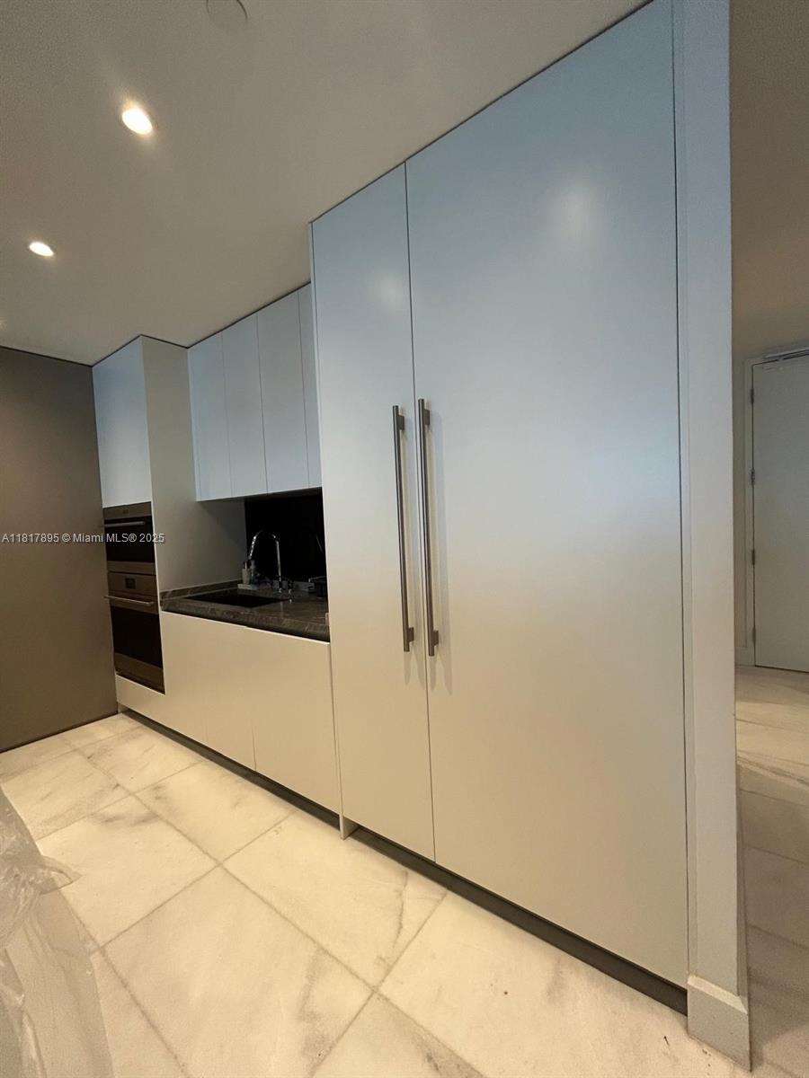700 Northeast 26th Terrace, Unit 2602 Miami, FL 33137 - Photo 8 of 38 a kitchen with a refrigerator and cabinets