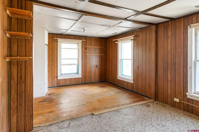 a view of empty room with wooden floor