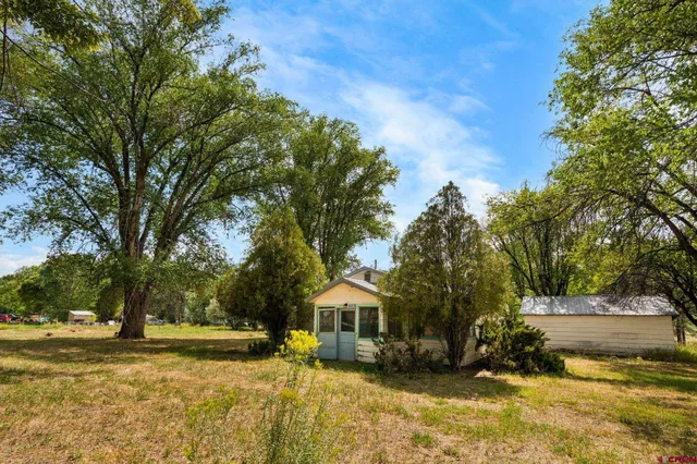 a front view of a house with a yard and trees