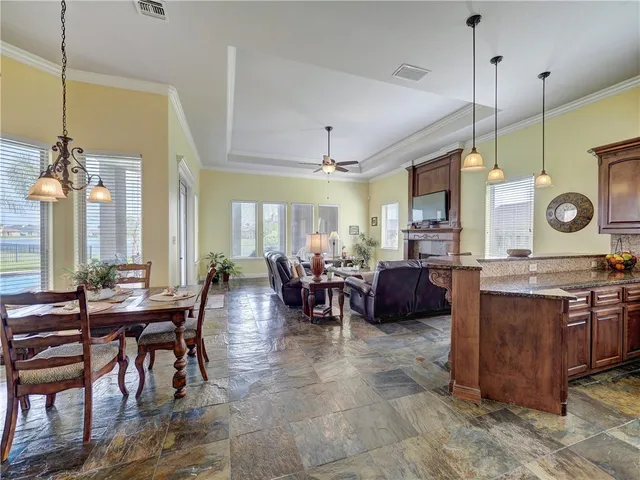 a living room with furniture a dining table and a fireplace