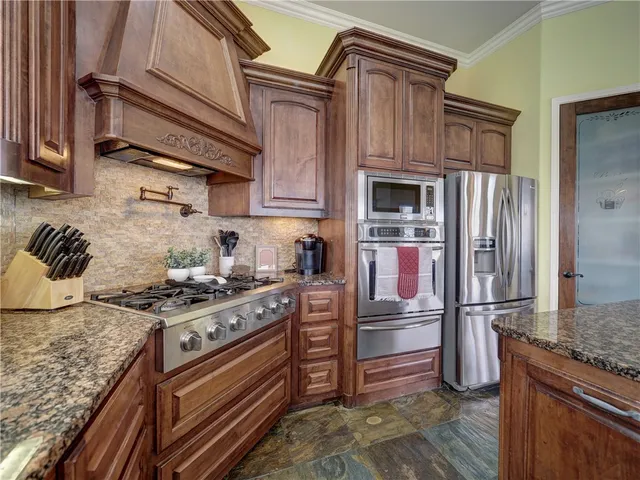 a kitchen with stainless steel appliances granite countertop a stove and a refrigerator