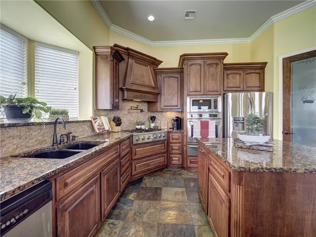 a kitchen with stainless steel appliances granite countertop a sink and cabinets