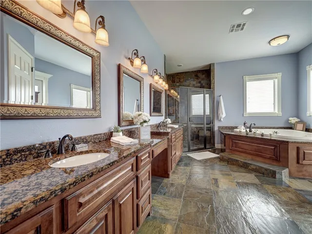 a spacious bathroom with a granite countertop sink a mirror and a