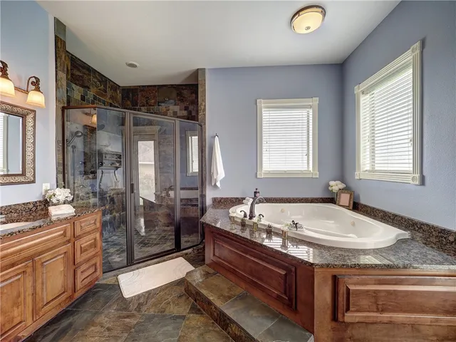 a spacious bathroom with sink shower bathtub and window