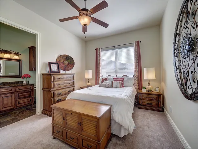 a bedroom with a bed and a flat tv screen on the dresser
