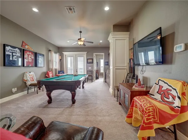 a living room with furniture a flat screen tv and kitchen area