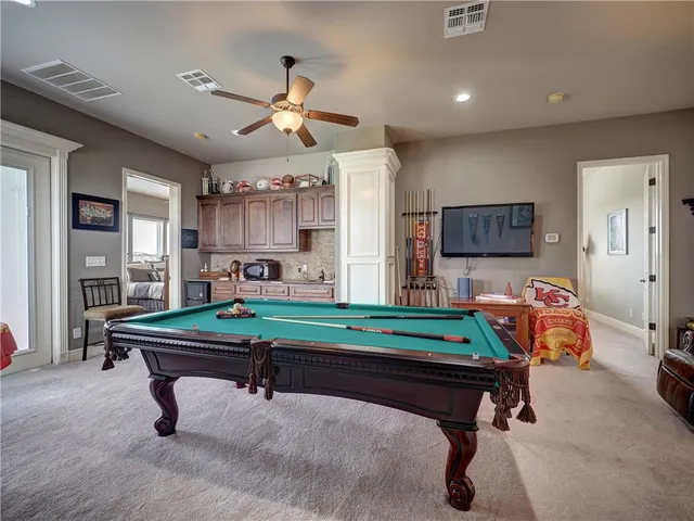 a room with pool table and windows