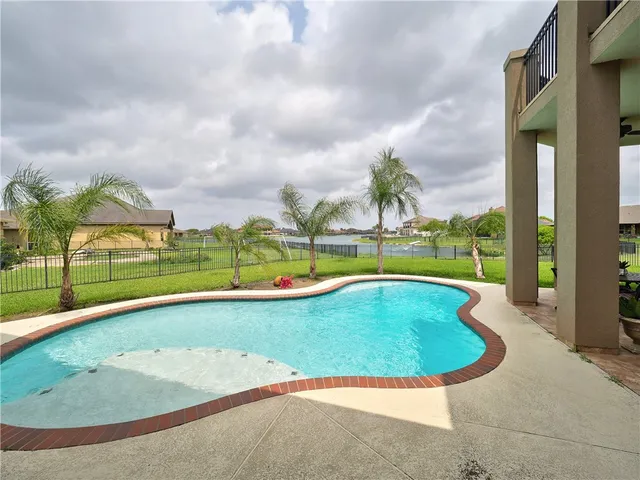 a view of a big house with a big yard and large trees
