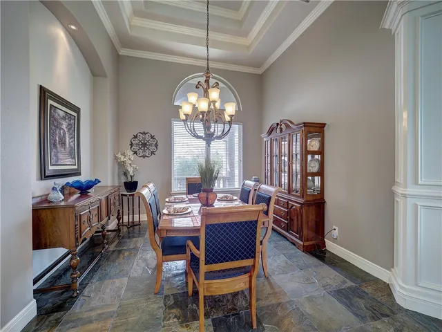 a view of a dining room with furniture and a chandelier