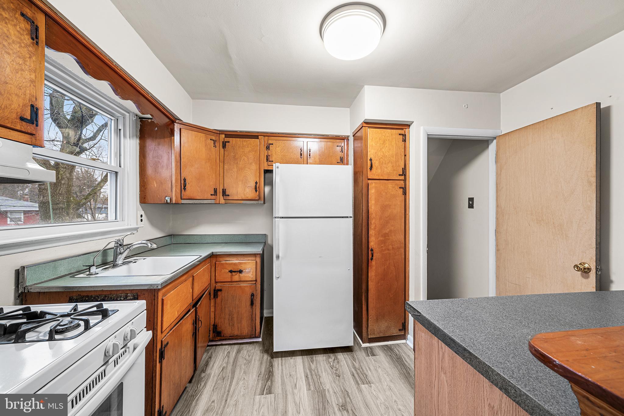 1108 Providence Road Secane, PA 19018 - Photo 11 of 33 a kitchen with a refrigerator a stove a sink and wooden floor
