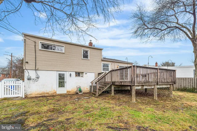 a backyard of a house with table chairs and wooden fence