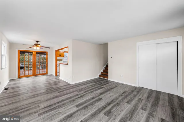 a view of an empty room with wooden floor and entryway