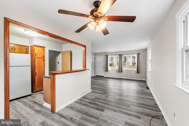 a view interior of a house with wooden floor a ceiling fan and windows