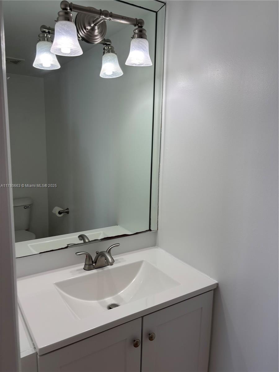 2415 Northwest 16th St Road, Unit 103 Miami, FL 33125 - Photo 12 of 42 a bathroom with a sink and a mirror