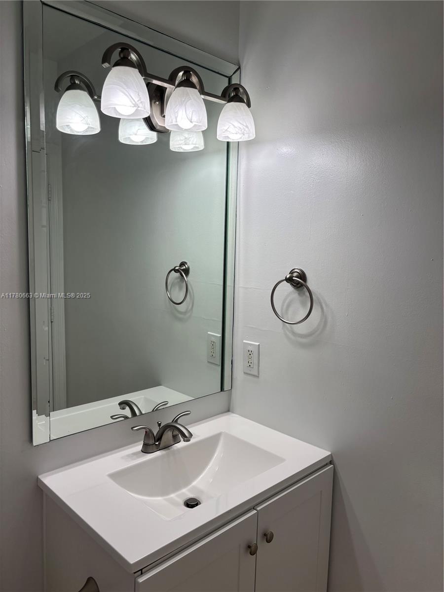 2415 Northwest 16th St Road, Unit 103 Miami, FL 33125 - Photo 20 of 42 a bathroom with a sink mirror and vanity