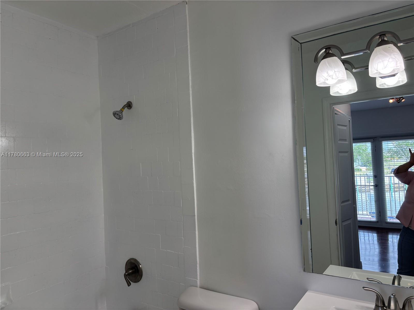 2415 Northwest 16th St Road, Unit 103 Miami, FL 33125 - Photo 22 of 42 a bathroom with a toilet and a mirror