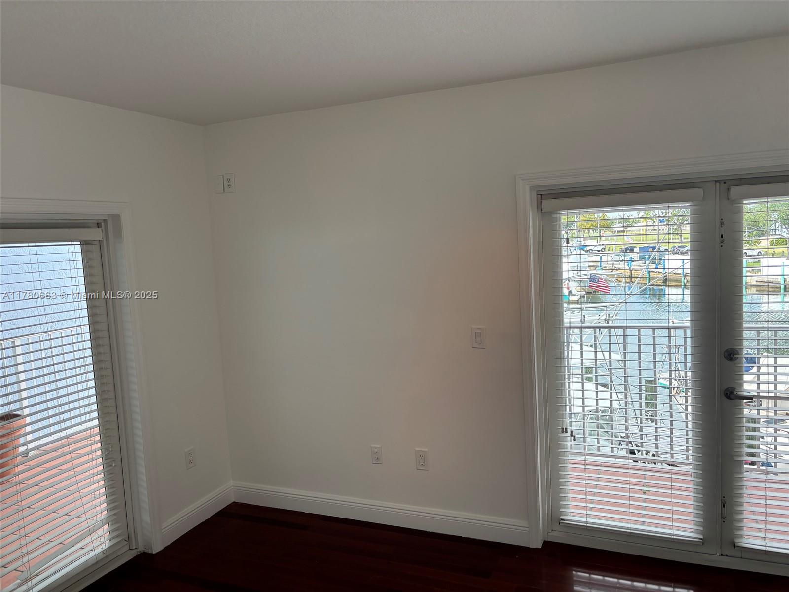 2415 Northwest 16th St Road, Unit 103 Miami, FL 33125 - Photo 26 of 42 an empty room with wooden floor and windows