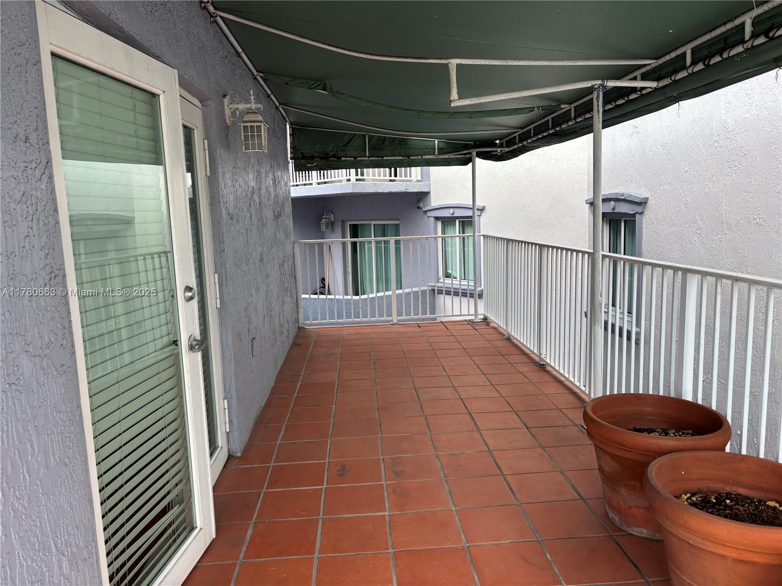 2415 Northwest 16th St Road, Unit 103 Miami, FL 33125 - Photo 29 of 42 a view of a porch with wooden floor
