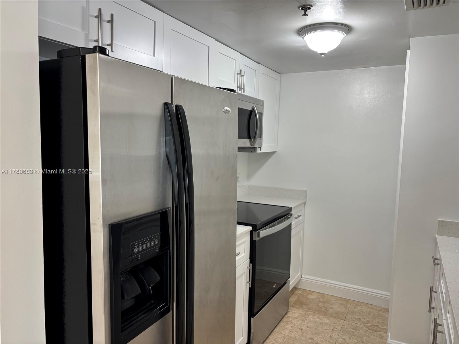 2415 Northwest 16th St Road, Unit 103 Miami, FL 33125 - Photo 37 of 42 a metallic refrigerator freezer sitting in a kitchen