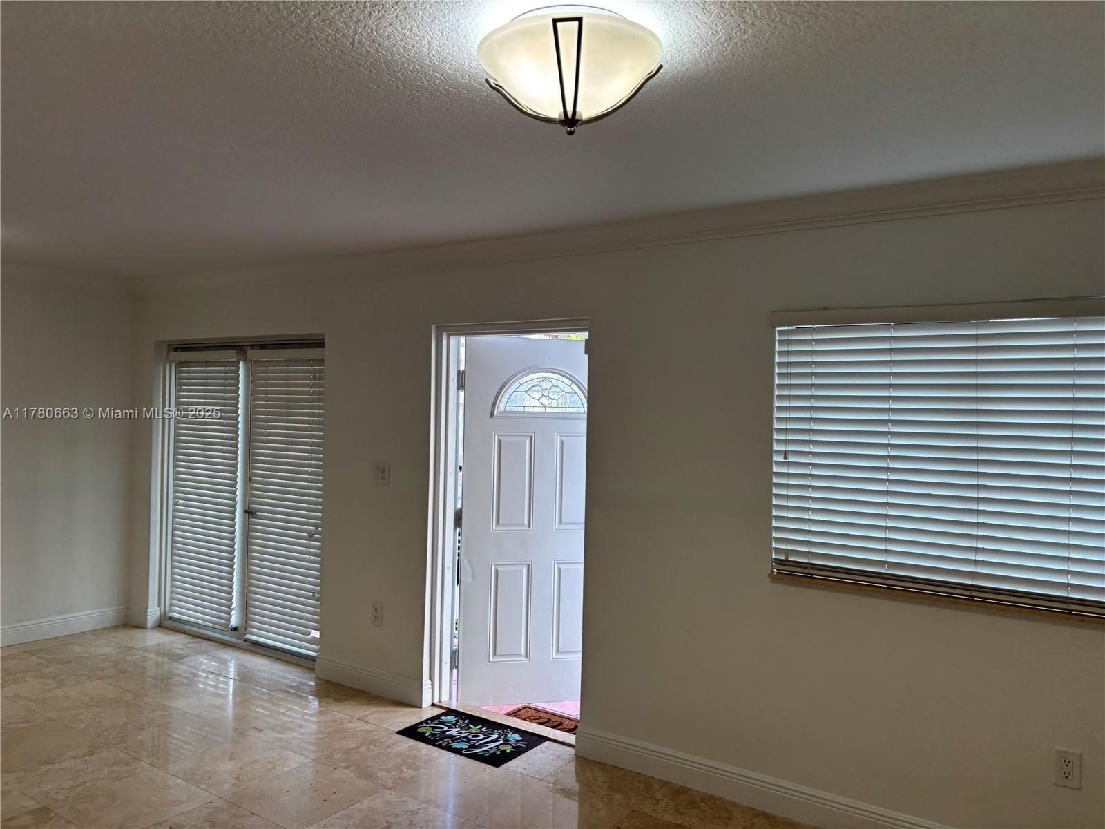 2415 Northwest 16th St Road, Unit 103 Miami, FL 33125 - Photo 6 of 42 an empty room with wooden floor and windows