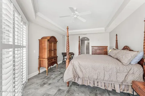 a bedroom with a large bed and a chandelier