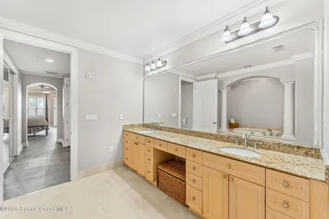 a bathroom with a granite countertop double vanity sink and a mirror