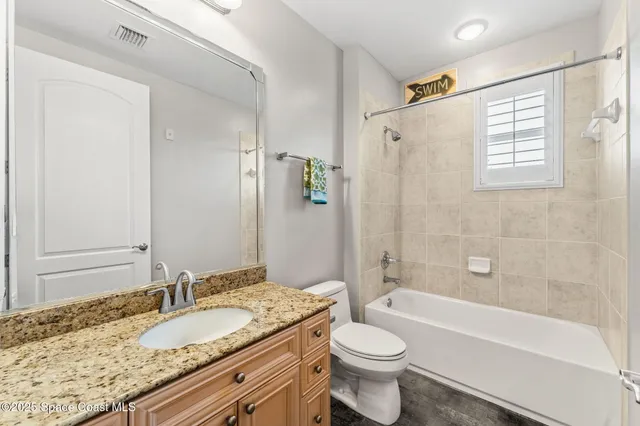 a bathroom with a granite countertop sink toilet mirror and bathtub