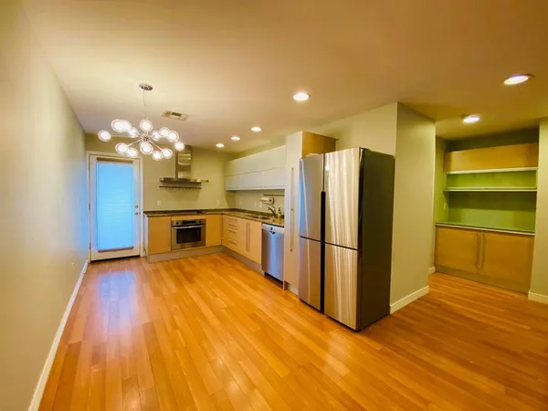 a kitchen with stainless steel appliances granite countertop a refrigerator and a sink