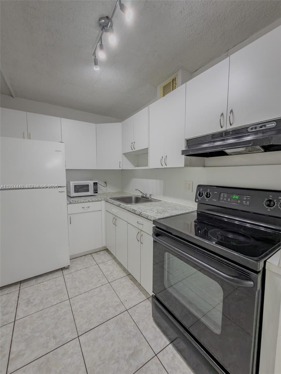 8411 Northwest 8th Street, Unit 301 Miami, FL 33126 - Photo 4 of 15 a kitchen with appliances and cabinets