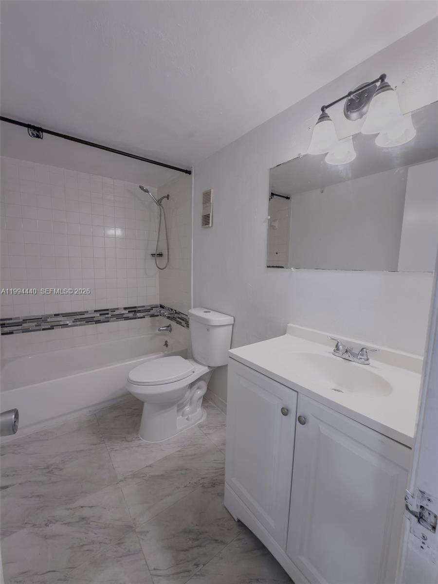 8411 Northwest 8th Street, Unit 301 Miami, FL 33126 - Photo 7 of 15 a bathroom with a toilet sink and mirror