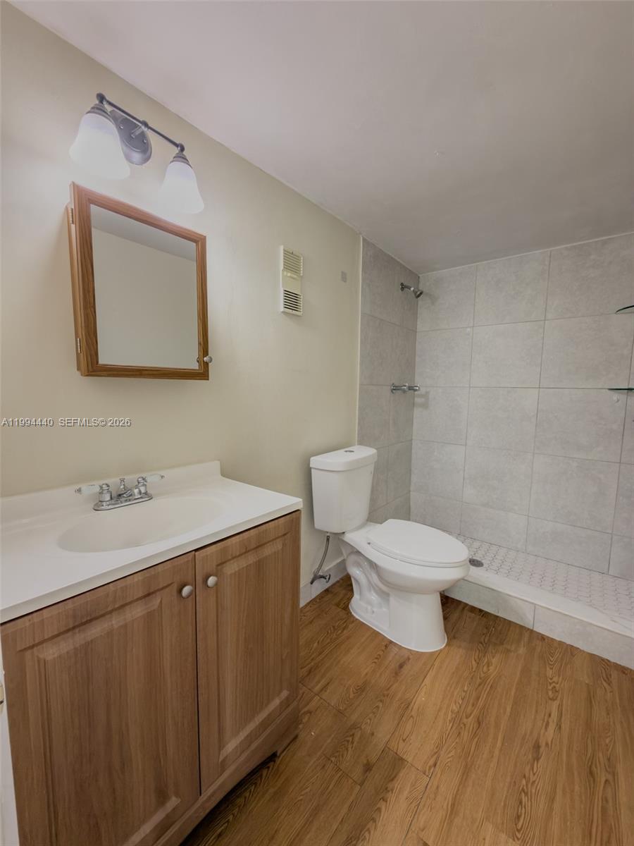 8411 Northwest 8th Street, Unit 301 Miami, FL 33126 - Photo 9 of 15 a bathroom with a toilet a sink and mirror