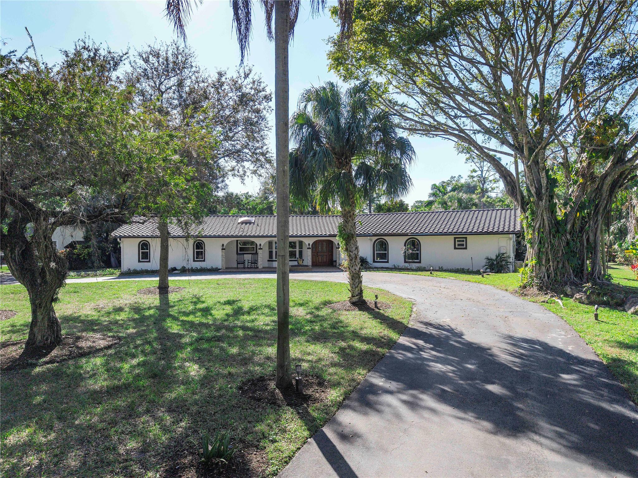 5351 Godfrey Road Parkland, FL 33067 - Photo 94 of 95 a house that has a tree in front of it