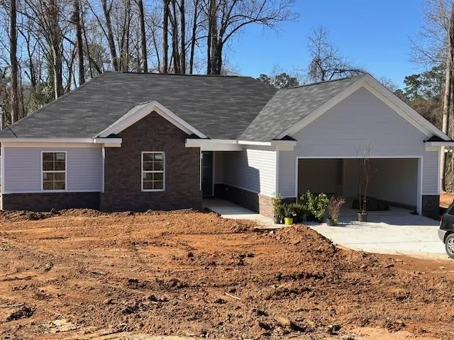 a front view of a house with a yard covered in snow