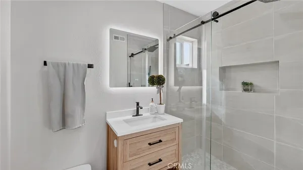 a bathroom with a shower sink and mirror