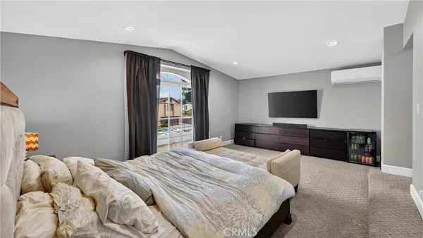 a bedroom with a bed and a flat screen tv