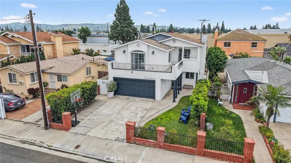 a aerial view of a house with a yard and potted plants