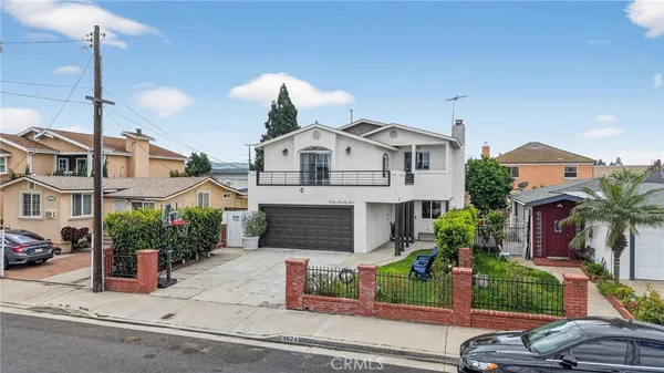 a front view of a house with a garden and plants